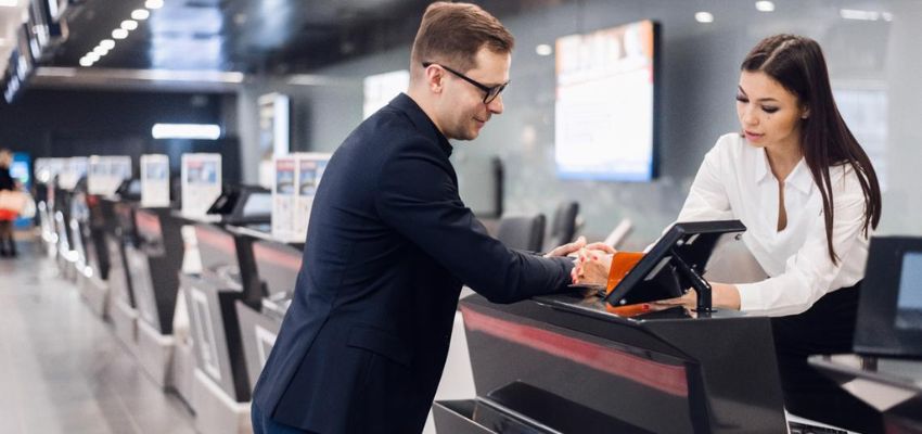 Male passenger with airport staff booking ticket